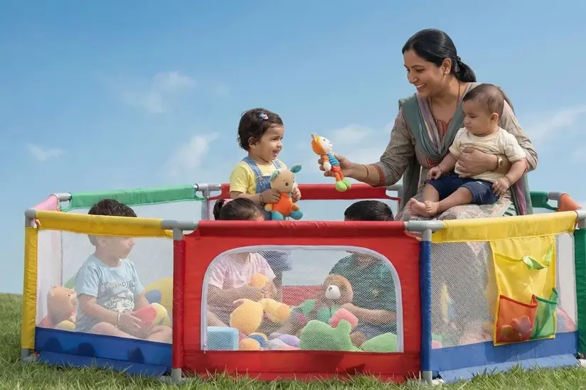 A woman is playing with children at a table.
